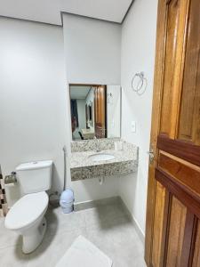 a bathroom with a toilet and a sink and a mirror at Hotel Colorado in Vilhena +16 photos