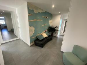 a living room with a chair and a couch at Le balcon du square in Rennes