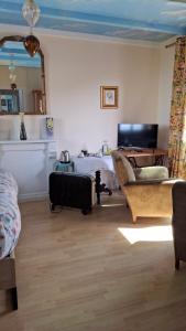 a living room with a bed and a suitcase at Chez Laurence in Locronan