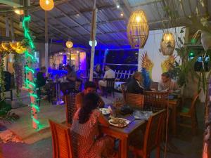 a group of people sitting at a table in a restaurant at Noname Hostel ella in Ella