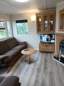 a living room with a couch and a table and a tv at Kalski Dworek in Węgorzewo