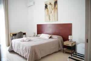 a bedroom with a large bed with a wooden headboard at Giocca Rooms in Palagiano