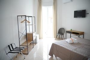 a bedroom with a bed and a desk and a television at Giocca Rooms in Palagiano
