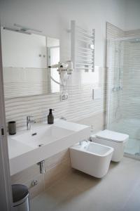 a white bathroom with a sink and a toilet at Giocca Rooms in Palagiano
