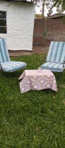 two chairs and a blanket on the grass next to at tómate un descanso in Salto