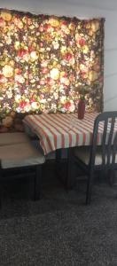 a table and a chair in front of a flower wall at tómate un descanso in Salto