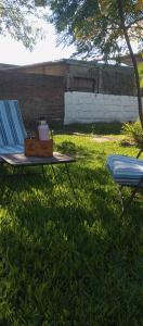 a picnic table in the grass with a tea kettle on it at tómate un descanso in Salto