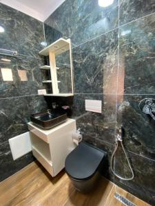 a bathroom with a sink and a toilet and a mirror at Kruja Apartment SA in Krujë