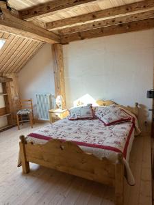 a bedroom with a wooden bed in a room at L'écho des Artois in Uzelle