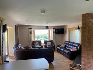 a living room with two brown leather couches at Hilltop in White Gate Cross Roads