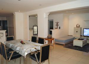 a dining room and living room with a table and chairs at Duplex T3 résidence Djnen el Bey in Annaba