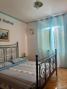 a bedroom with a bed and a window with blue curtains at Locanda D'Ogliastra in Triei