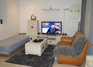 a living room with a tv and a bed and a couch at Duplex T3 résidence Djnen el Bey in Annaba