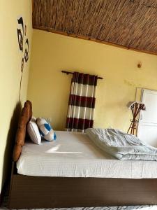 a bedroom with a bed with white sheets and pillows at Jungle Nirvana Retreat in Meghauli