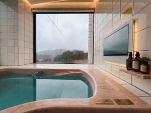 a swimming pool in a bathroom with a large window at ホテル アルファ in Iizaka