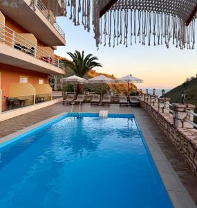 a hotel swimming pool with a view of the ocean at Karos Hotel Llaman in Himare