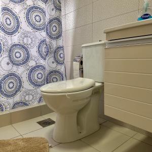 a bathroom with a toilet and a shower curtain at In The House Hostel in Prishtinë +88 photos