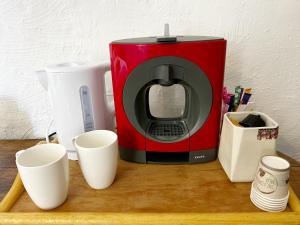 a red coffee maker sitting on a counter with cups at Le petit refuge in Allos +6 photos