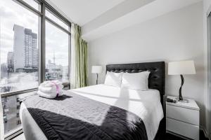 a bedroom with a bed and a large window at Adelaide Stays and Suites - Walk to Subway - Easy Access Downtown Toronto in Vaughan +41 photos