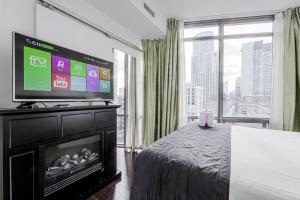 a bedroom with a flat screen tv on top of a fireplace at Adelaide Stays and Suites - Walk to Subway - Easy Access Downtown Toronto in Vaughan