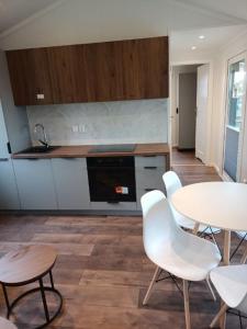 a kitchen with a table and white chairs and a counter at Kalski Dworek in Węgorzewo
