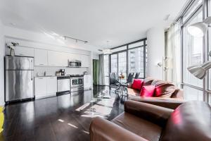 a living room with a couch and a kitchen at Adelaide Stays and Suites - Walk to Subway - Easy Access Downtown Toronto in Vaughan