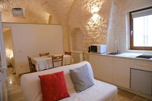 a living room with a couch and a kitchen with a table at Campanile Inn in Locorotondo