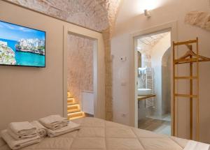 a bedroom with a bed and a tv on a wall at Campanile Inn in Locorotondo