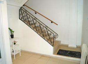 a staircase with a wrought iron railing in a house at Duplex T3 résidence Djnen el Bey in Annaba +6 photos