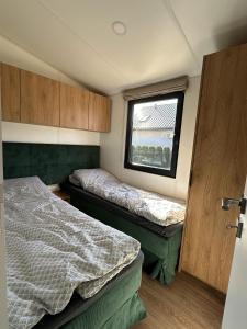 a small bedroom with two beds and a window at EkoOazy nad Jeziorem in Firlej