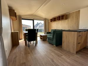 a living room with a green couch and a table at EkoOazy nad Jeziorem in Firlej