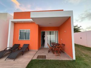 a patio with chairs and a table in front of a house at Cantinho Jauá 3 in Camaçari