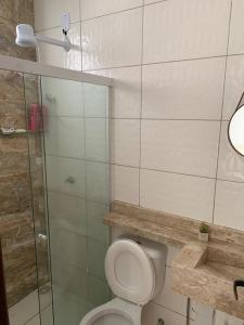 a bathroom with a toilet and a glass shower at Cantinho Jauá 3 in Camaçari