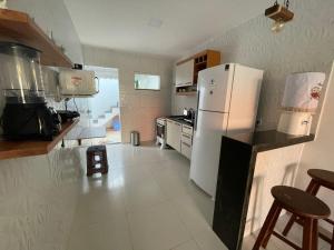 a kitchen with a white refrigerator and a counter top at Cantinho Jauá 3 in Camaçari