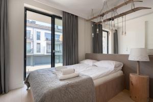 a bedroom with a bed and a large window at Kryształ Górski apartament z sauną in Szczyrk