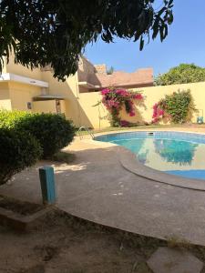 a swimming pool in front of a building at Villa & Appartement Du Soleil Ngaparou in Ngaparou