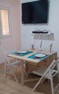a table with two chairs and a television on a wall at Sète Centre ville T2 rénové in Sète