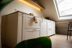 a kitchen with white cabinets and a window at Polderloft 27 in Hengstdijk +39 photos