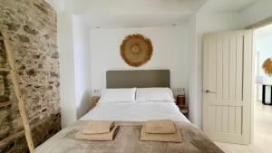 a bedroom with a bed with two towels on it at TarifaMiCasa Amor de Dios in Tarifa