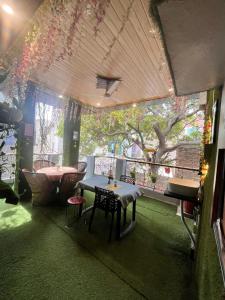 a room with a table and a tree in it at The Little Braj Homestay in Mathura