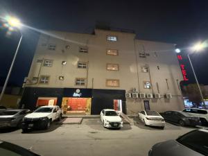 a parking lot with cars parked in front of a building at واحة الاحساء للشقق المخدومة in Al Hofuf