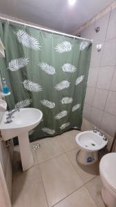 a bathroom with a shower curtain with a sink and a toilet at Depto Diucon Centro in Esquel