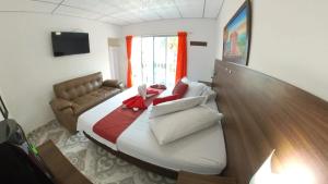 a bedroom with a large bed and a couch at Hotel terranova in Melgar
