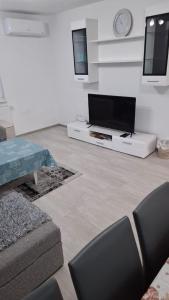 a living room with a flat screen tv and a couch at Quiet apartment in Hadžići