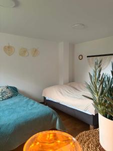 a bedroom with two beds and a table with a plant at Dolina Świtu in Pokrzywna