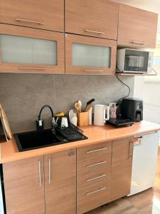 a kitchen with wooden cabinets and a sink at Dolina Świtu in Pokrzywna +6 photos