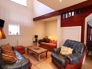 a living room with a leather couch and a table at Ballynacree Manor House in Balnamore