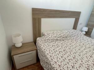 a bedroom with a bed with a wooden headboard and two lamps at Penismar Azul in Peniscola +21 photos