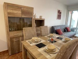 a dining room with a table with chairs and a couch at Penismar Azul in Peniscola