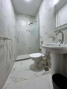 a white bathroom with a sink and a toilet at pyramids shadow inn hotel in Cairo
